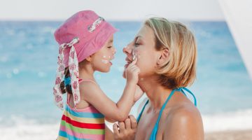 Umsichtiges Sonnenschutz-Verhalten im Alltag, der Freizeit und im Urlaub lernen Kinder von ihren Eltern.